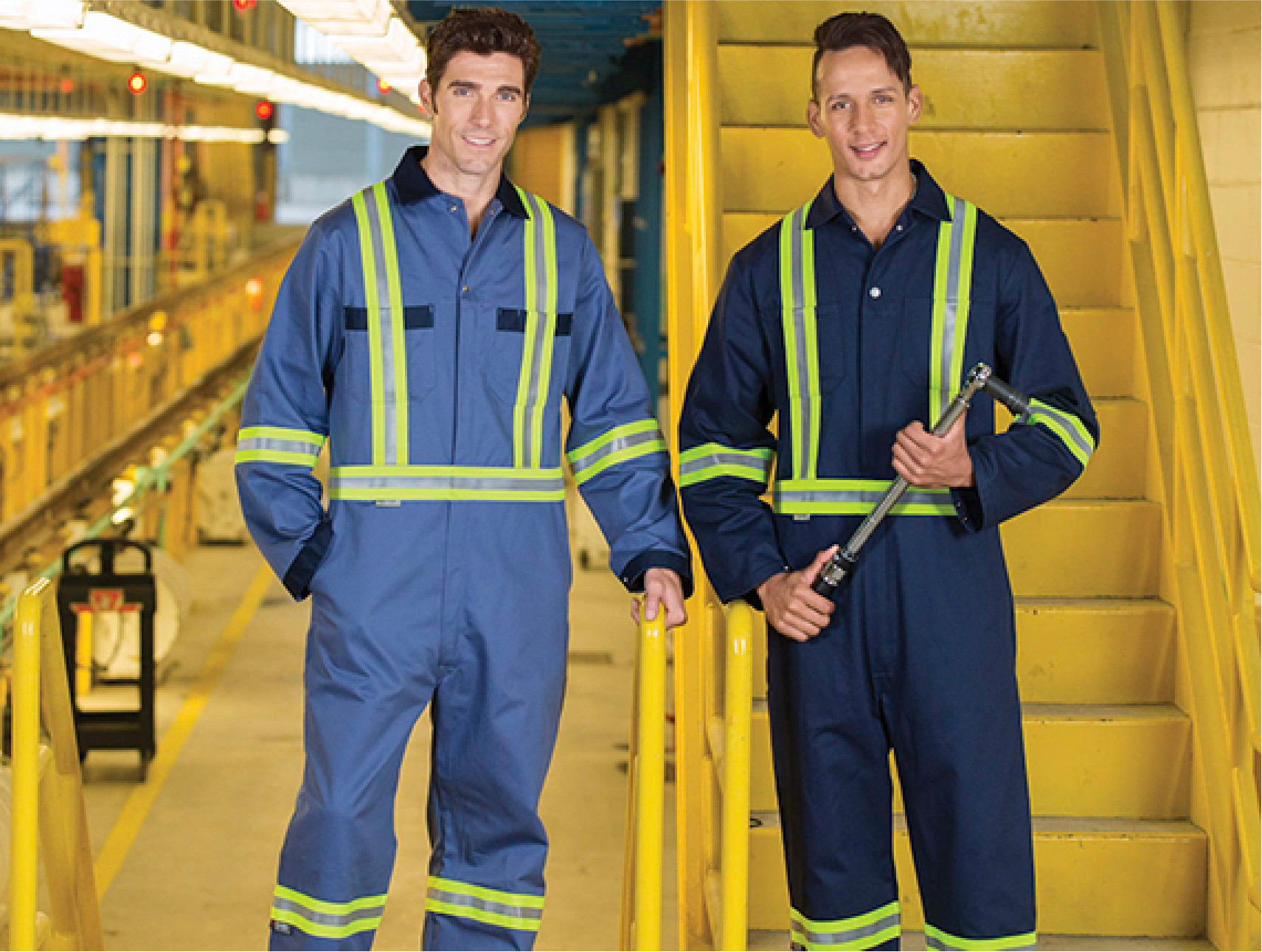 Two industrial workers wearing hi-visibility shirts and pants