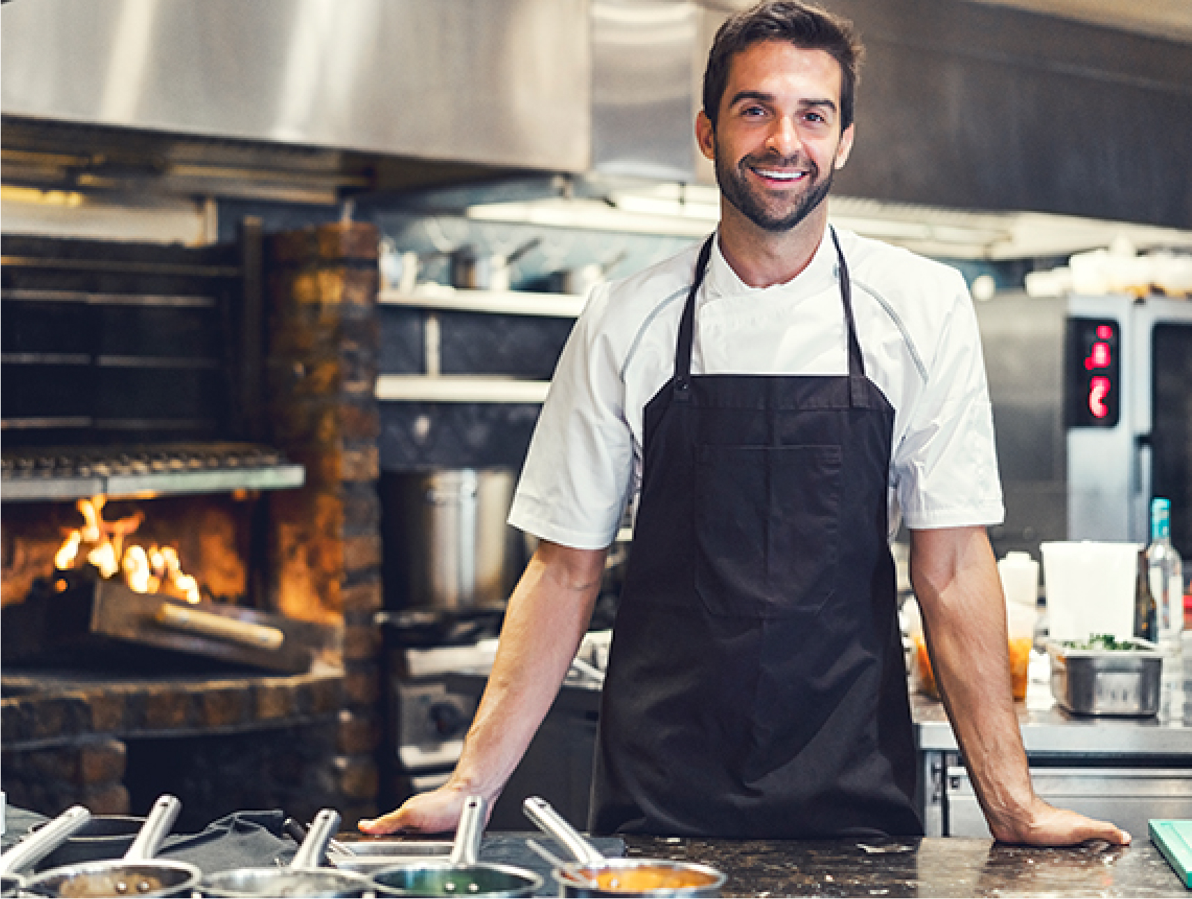 Man smiling in kitchen wearing an apron