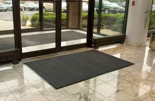 A spacious entrance mat placed in front of a sizable glass door.