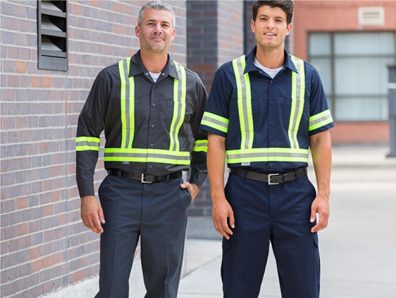 Two industrial workers wearing hi-visibility shirts and pants