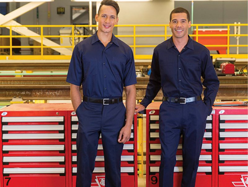 Two men wearing work shirts and work pants