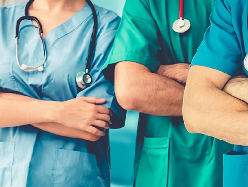 Three people wearing scrubs