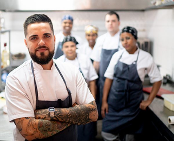 A group of kitchen staff wearing chef coats and aprons